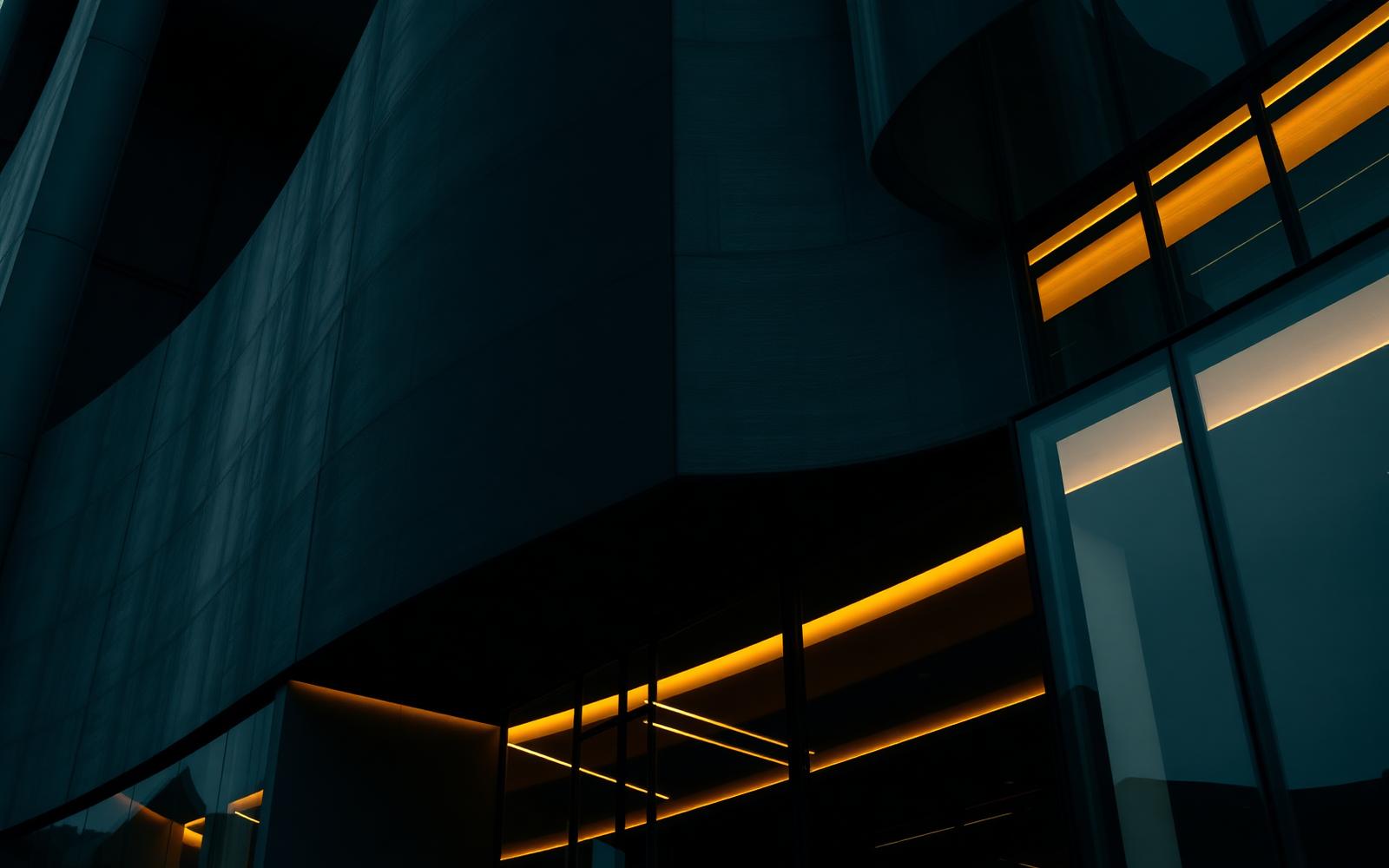 Dark sculptural architecture with champagne light — restraint and material honesty